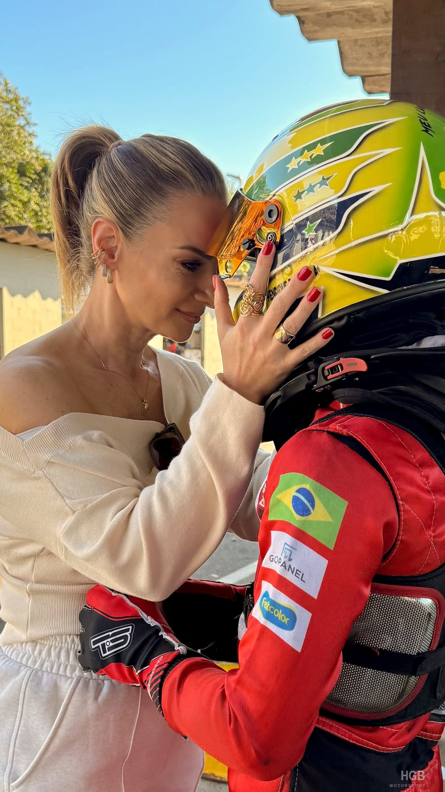 Sandra, mãe de Henrique, com as mãos no capacete do filho antes da corrida